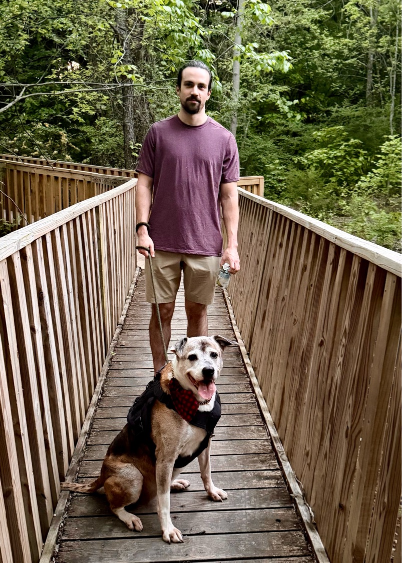 Preston Danielson with his dog on a footbridge